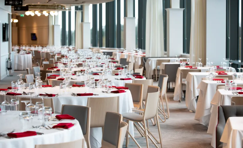 Poppy Red napkins in a stadium setting with Arctic White table cloths used as a base