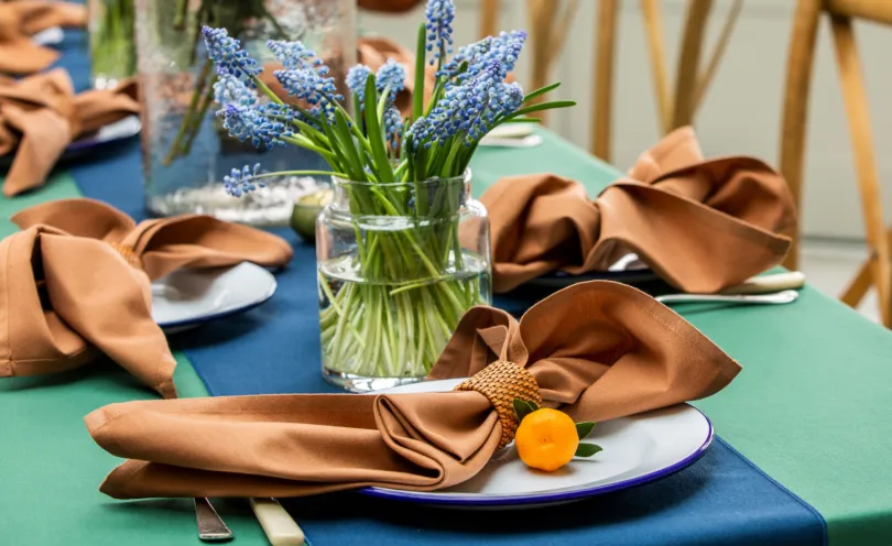 Cinnamon napkins with Oxford Blue table runner on Forest Green table cloth