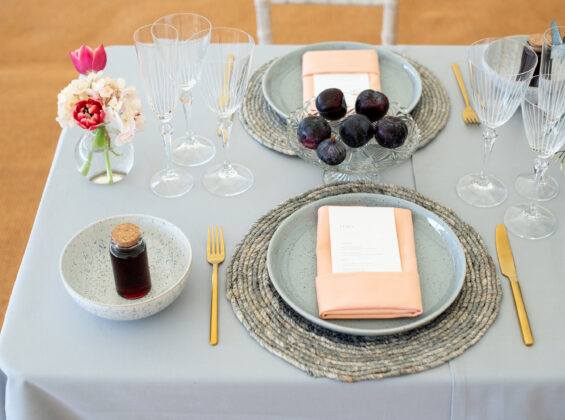 Two Coral napkins on a Pebble Grey table cloth