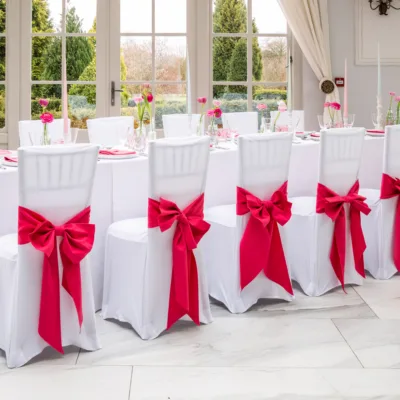 Pink Fuchsia napkins, chair sashes and bows on a base of Arctic White stretch chair covers and table cloths