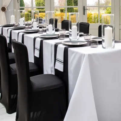 Jet-Black table runners and stretch chair covers with Arctic White table cloths and Black Strip Bistro Napkins